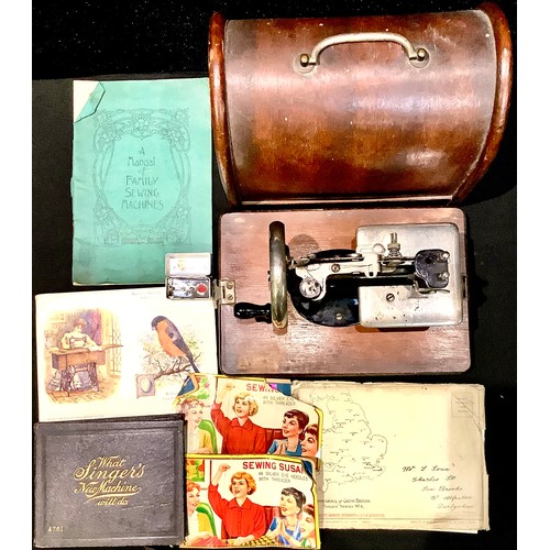 226 - A Lead miniature sewing machine, domed carry case; some related Singer and other sewing ephemera