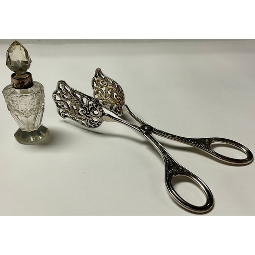 242 - A pair of Continental white metal asparagus tongs; a silver mounted cut glass scent bottle, London 1... 