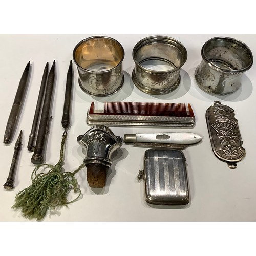 245 - Three silver napkin rings; a silver vesta case, Birmingham; a mother of pearl fruit knife; a travell... 