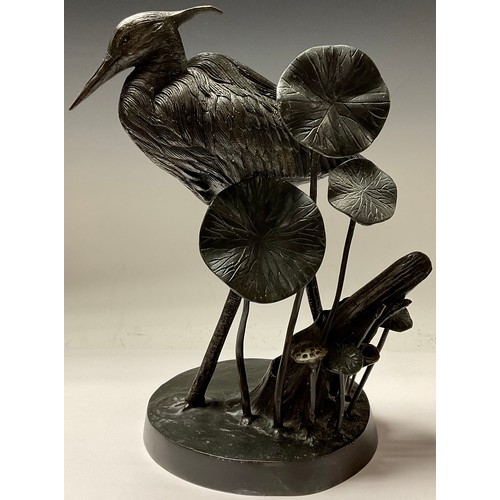 352 - A French dark patinated spelter model of a heron amongst lily pads, 37cm high