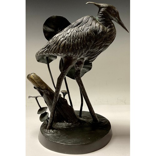 352 - A French dark patinated spelter model of a heron amongst lily pads, 37cm high