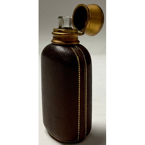 190A - A 19th century burnished gilt metal and tooled leather scent bottle, hinged cover enclosing a stoppe... 