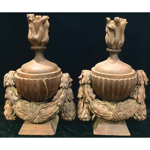 600 - A pair of substantial carved oak lamps as flaming pedestal urns, each with carved oak swags, 64cm hi... 