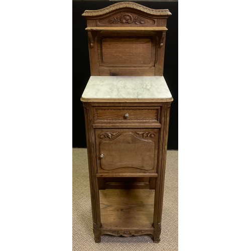 13 - An early 20th century French marble top bedside cabinet / pot cupboard, carved oak back-splash with ... 