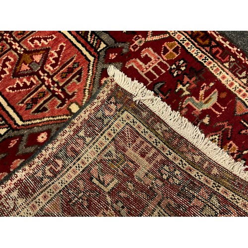 50 - A Persian Karajeh runner carpet / rug, hand-knotted in tones of red, grey, pink, and cream, with a c... 