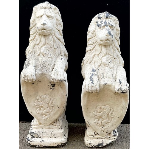 1775A - A pair of reconstituted heraldic garden lions rampant, each supporting a shield, 82cm high