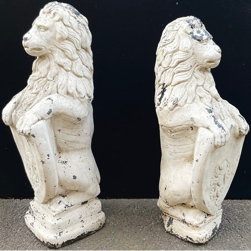 1775A - A pair of reconstituted heraldic garden lions rampant, each supporting a shield, 82cm high