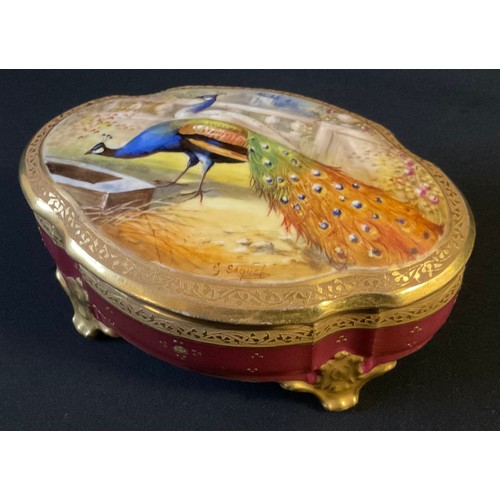 13 - A 20th century Limoges shaped oval trinket box, the cover painted by Saquet, signed with peacock and... 