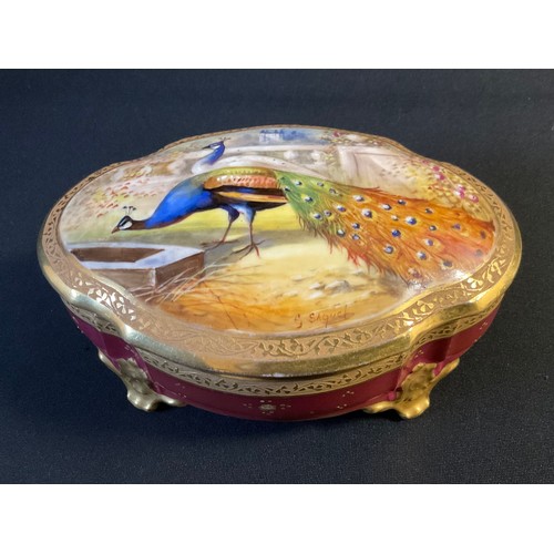 13 - A 20th century Limoges shaped oval trinket box, the cover painted by Saquet, signed with peacock and... 