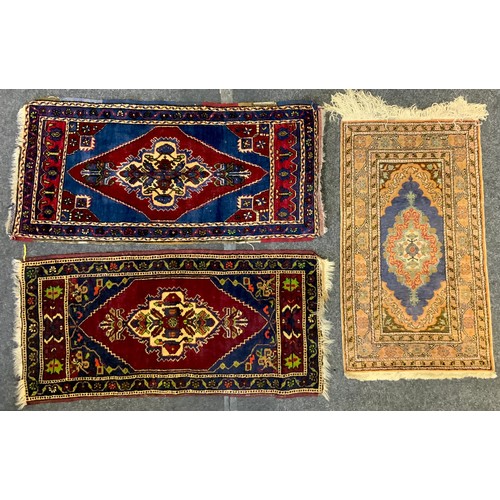 28 - A Turkish wool rug, stylised flowers on a blue and red ground, 116cm long, 55cm wide;  others, 124cm... 