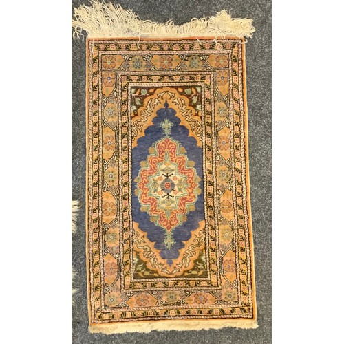 28 - A Turkish wool rug, stylised flowers on a blue and red ground, 116cm long, 55cm wide;  others, 124cm... 