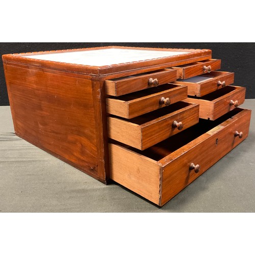 54 - A mahogany Dentists pharmaceutical  table-top chest, having an arrangement of seven graduated drawer... 