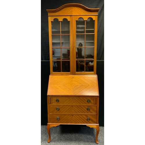 264 - A mid 20th century mahogany and satinwood bureau bookcase, serpentine top, glazed doors enclosing th... 