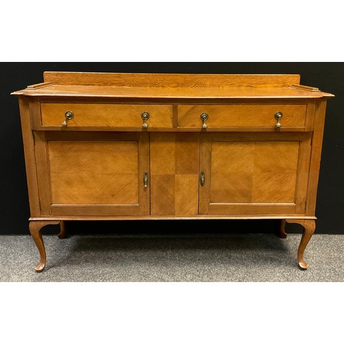 284 - An oak sideboard, over-sailing top with pair of short drawers over two cupboard doors, cabriole legs... 