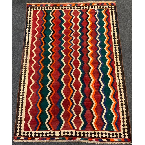 299 - A South-West Persian Qashgai Kilim rug / carpet, knotted in tones of red, blue, green, black, and or... 