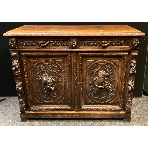 307 - An early 20th century French carved oak sideboard / Duodarn base, the over-sailing top above a pair ... 