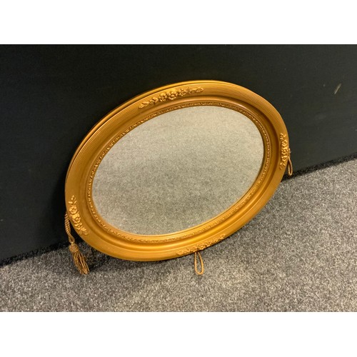 354 - An early 20th century French gilt wood oval looking glass, 51cm x 61.5cm, bevelled glass.