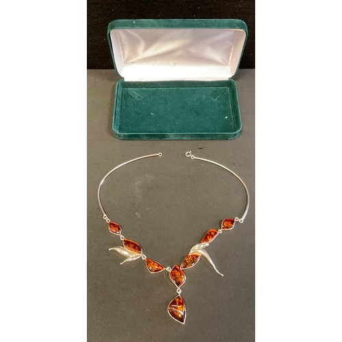 385 - An amber and silver pendant necklace, set with eight shaped amber lozenges within 925 silver leaf fr... 