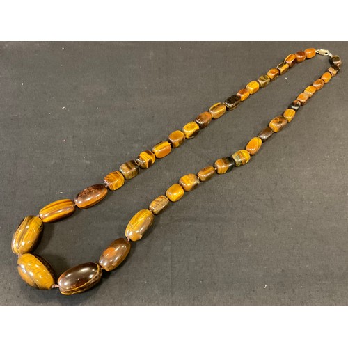 388 - A set of graduated Tiger Eye beads, 84cm long, silver clasp