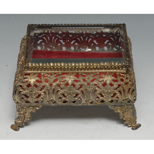 35 - A French gilt metal circular dressing table box,  shaped handle, the glazed lid set with lace and si... 