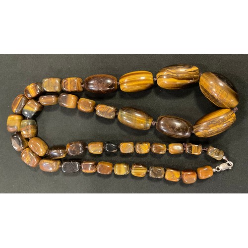 388 - A set of graduated Tiger Eye beads, 84cm long, silver clasp