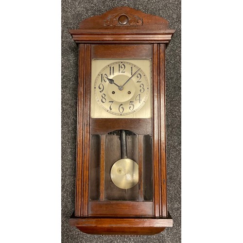 29 - An early 20th century oak cased wall clock, carved cresting, silvered face with Arabic numerals, gla... 