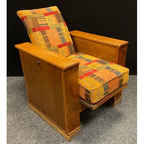 63 - A 1930s Art Deco (possibly Heal’s) oak reclining arm book chair, each arm opening with fall sides, s... 