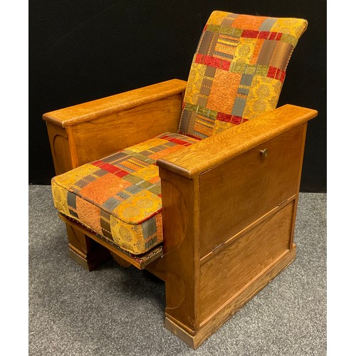 63 - A 1930s Art Deco (possibly Heal’s) oak reclining arm book chair, each arm opening with fall sides, s... 