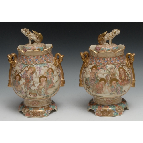 18 - A pair of Japanese satsuma jars and covers, painted in polychrome with elders engaged in games and p... 