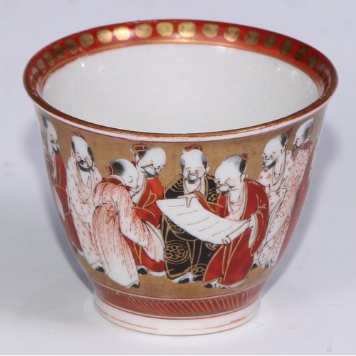 69 - A Japanese sake service, comprising a wine pot and a pair of cups, painted in the Kutani palette wit... 