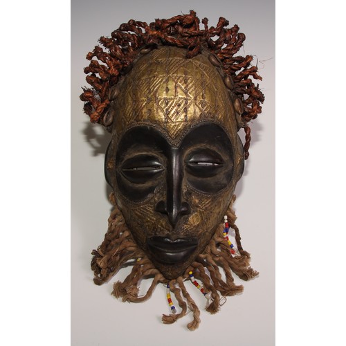 711 - Decorative Tribal Art and the Eclectic Interior - a West African mask, stylised eliptical features, ... 