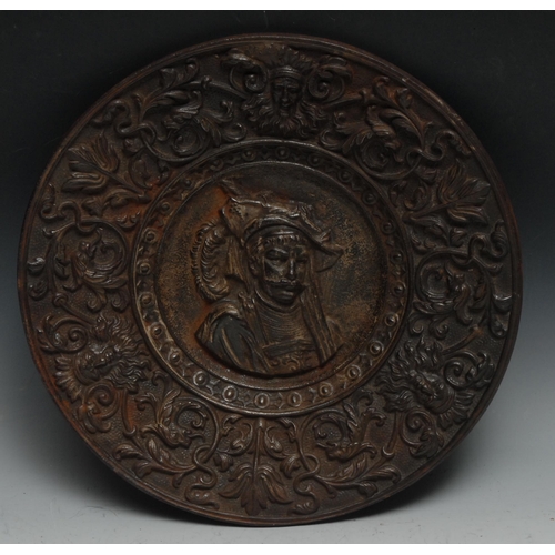 39 - A 19th century Continental circular cast metal plate, the central field cast with a gentleman with f... 