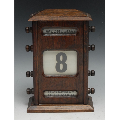 536 - An early 20th century oak perpetual calendar, sarcophagus cresting above glazed apertures for day, d... 