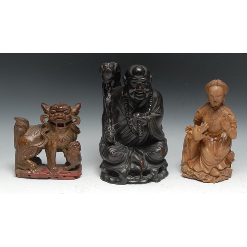 291 - A Chinese hardwood figure, of a Buddhist monk, seated, holding a fly whisk, 26cm high; another, of a... 