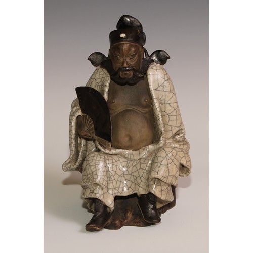 301 - A Chinese Shiwan stoneware figure, of an elder holding a fan, crackle glazed robe, 23.5cm high, earl... 