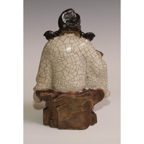 301 - A Chinese Shiwan stoneware figure, of an elder holding a fan, crackle glazed robe, 23.5cm high, earl... 