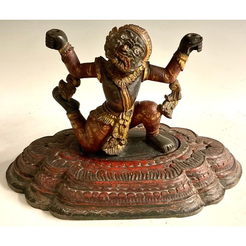 466 - A South Asian polychrome carving, of a demon, stepped lotus base, 46cm wide, 19th/early 20th century