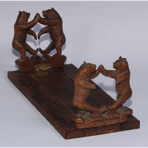 57 - A Black Forest novelty book slide, each folding end support carved with dancing bears, 31cm wide, ea... 