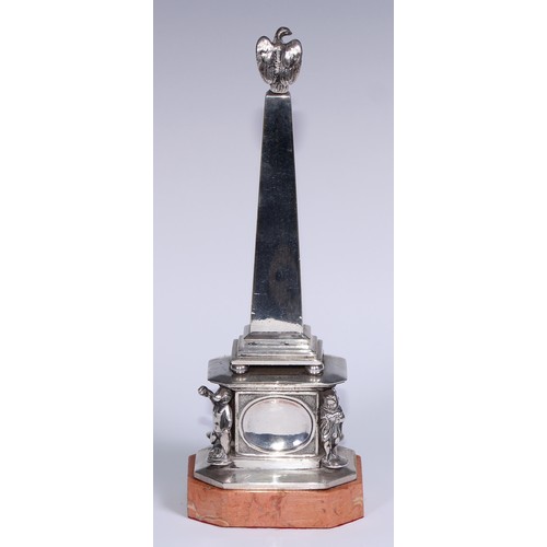 538 - An early 20th century silvered obelisk desk thermometer, eagle finial, the friece with bas relief an... 