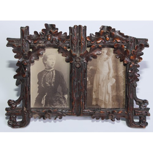 56 - A Black Forest easel double photograph frame, carved with fruiting oak, 20.5cm wide, c.1900