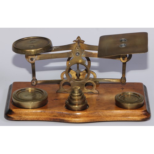 453 - A set of early 20th century brass and walnut postal scales, serpentine base, 21cm wide, c.1920