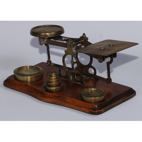 453 - A set of early 20th century brass and walnut postal scales, serpentine base, 21cm wide, c.1920