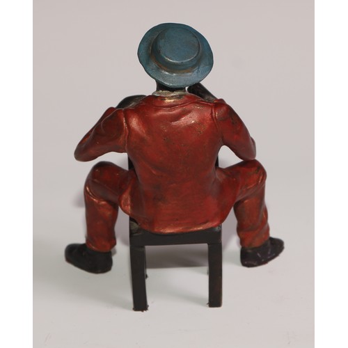 308 - A cold painted bronze, of a Mississippi dandy, finely dressed and seated backwards on a chair, 13cm ... 