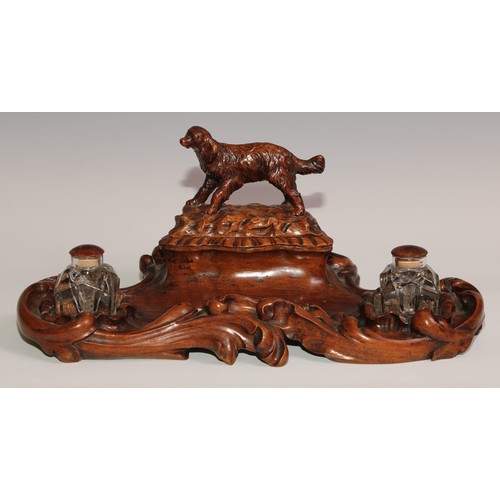 274 - A 19th century walnut desk stand, carved in the Black Forest manner, the central compartment enclose... 