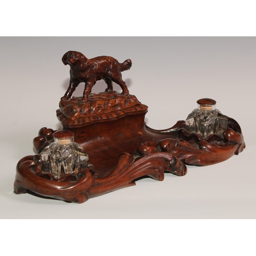 274 - A 19th century walnut desk stand, carved in the Black Forest manner, the central compartment enclose... 