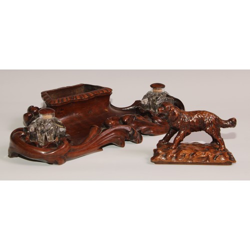 274 - A 19th century walnut desk stand, carved in the Black Forest manner, the central compartment enclose... 