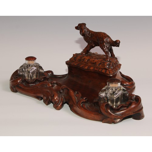 274 - A 19th century walnut desk stand, carved in the Black Forest manner, the central compartment enclose... 