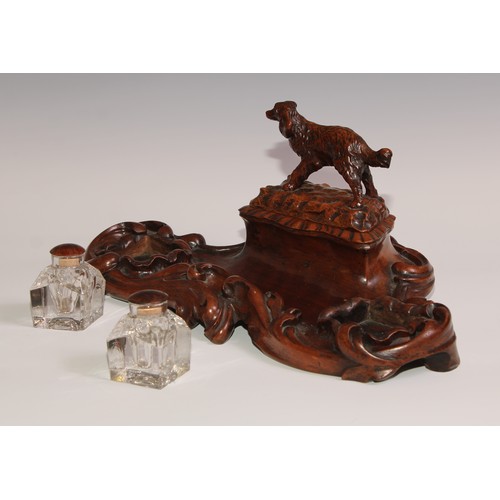 274 - A 19th century walnut desk stand, carved in the Black Forest manner, the central compartment enclose... 