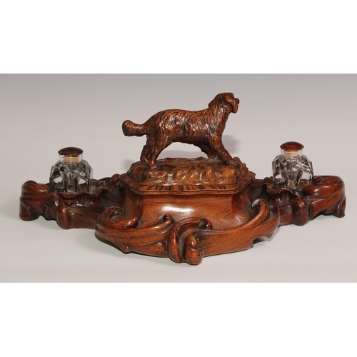 274 - A 19th century walnut desk stand, carved in the Black Forest manner, the central compartment enclose... 