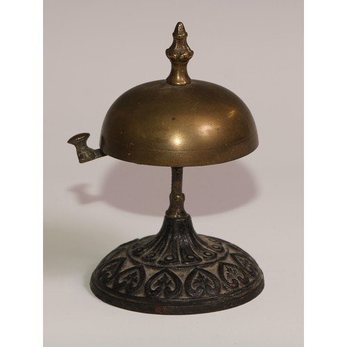 34 - A 19th century cast iron and brass desk or table bell, the base in relief with palmettes and lotus, ... 